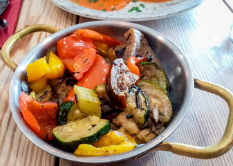 Italian cooked vegetable dish place on the restaurant dining table.