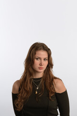 Portrait of a young girl in black. white background. Black jacket. Caucasian. brunette. neutral look. Vertical