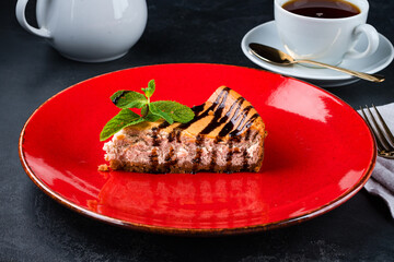 Piece of fresh cheesecake with chocolate sauce and mint.