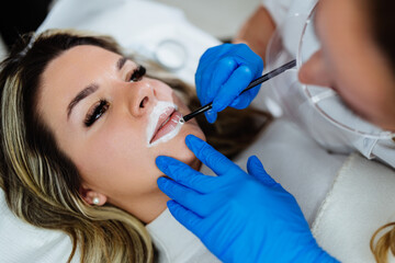 Professional permanent make up procedure. Tattoo lips makeup treatment in modern beauty salon.