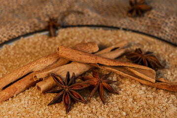 Spices for baking. Cinnamon sticks and star anise lie on cane sugar