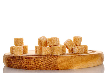 Several cubes of brown sugar on a wooden tray, close-up, isolated on white.