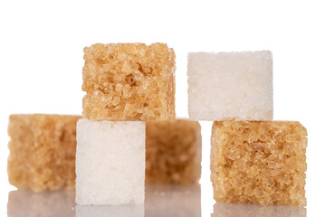 Several cubes of white and brown sugar, close-up, isolated on white.