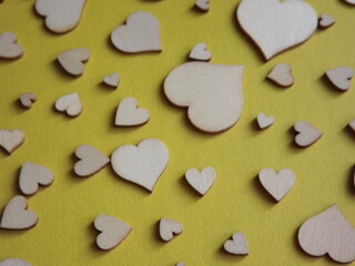 wooden hearts of different sizes on a yellow background. valentine's day, a declaration of love