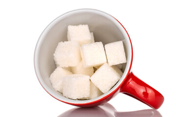 Several cubes of white sugar in a ceramic cup, close-up, isolated on white.