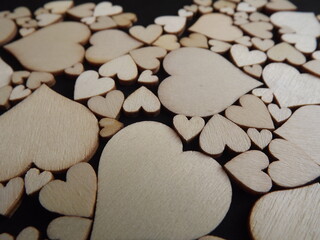 Obraz premium Wooden hearts on a black background as a postcard for the holidays