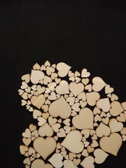 Wooden hearts on a black background as a postcard for the holidays. High quality photo
