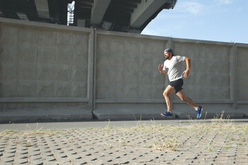 A man runs along the fence