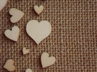 wooden hearts of different sizes on jute fabric as a Valentine's day greeting card. High quality photo