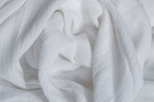 Wrinkled white viscose fabric. Artificial fiber from natural wood pulp. Textile texture as background