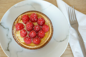 tasty dessert on plate. sweet pastry tart with fresh raspberries 