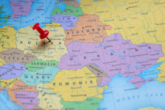 Warsaw city marked on a colorful map of Europe using a red push pin. The capital of Poland