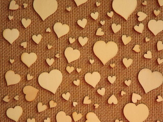 wooden hearts of different sizes on jute fabric as a Valentine's day greeting card. High quality photo