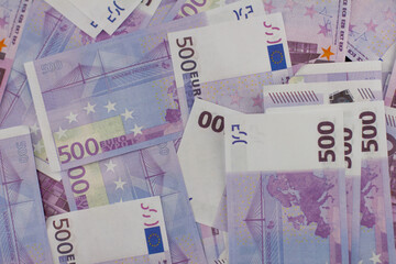 Background of euro bills lying in a thick layer. Bright pink five hundred euro banknotes lie on the table forming an even background. Concept background from euro money.