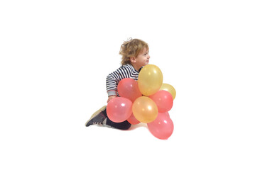 Fototapeta na wymiar side view of baby boy playing with a air balloon on ground on white background