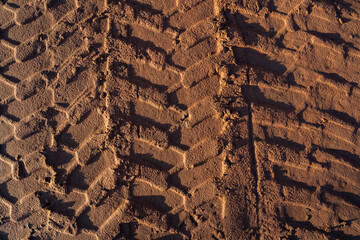 Brown sand with tire tracks from a wheel loader