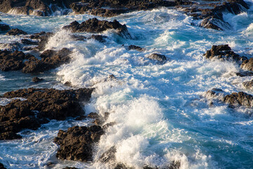 A close-up of a foamy water between rocks