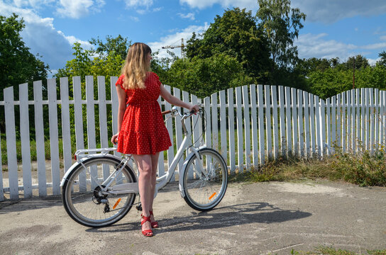 Full Body Portrait Of A Beautiful Woman Dressed In Red Short Dress Standing With Retro Bicycle Outdoors On The Natural Background Background