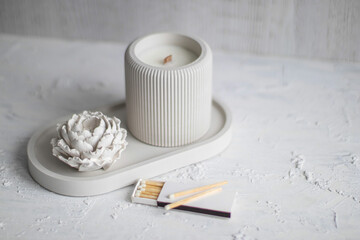 Candle, white color, in a unique candle holder concrete and oval coaster made from concrete in...