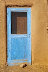Traditional blue door, painted for protection, in ancient Taos Pueblo Native American reservation, one of the oldest continuously inhabited communities in the United States, New Mexico, USA