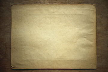Vintage blank sheet of paper on a wooden table in retro style.Antique document on the table with a clean background.