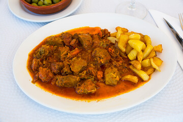 Close up of delicious baked in sauce pork cheeks served with potatoes on plate