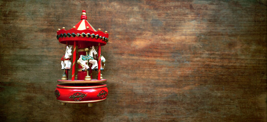 Antique toy musical carousel. The horses are spinning in a circle.Wooden vintage toy on an old...