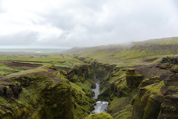 Fototapeta na wymiar Beautiful landscape with land covered in green moss in Iceland on a cloudy day