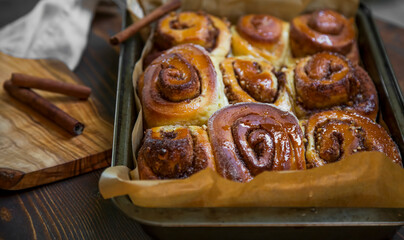 Freshly baked cinnamon and walnuts rolls, deliciously puffy pastry desserts - 568562938