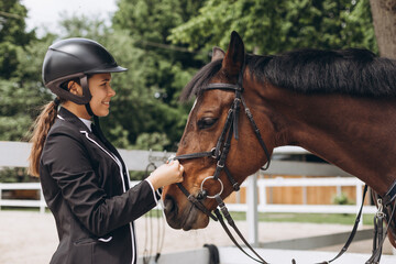 Equestrian sport - a young girl is standing near horse