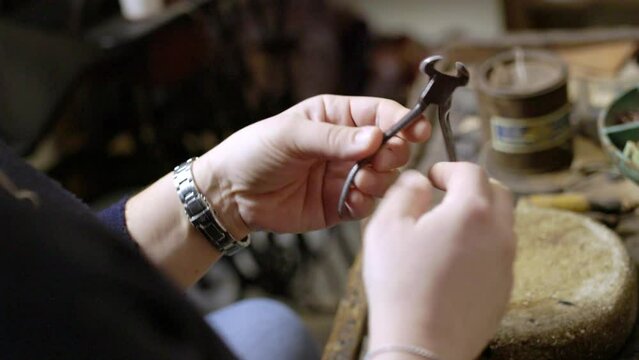 woman examining an old shoemaker claw