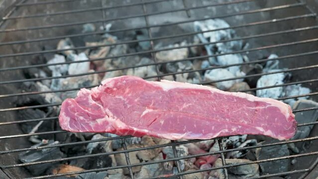 Man cooking and rotating beaf steakes on grill. 4k video footage