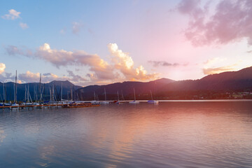 Lake and yachts against the backdrop of a mountain landscape at sunset.