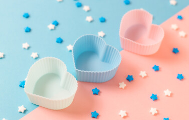 Muffin heart shape and candy sprinkles on pink and blue.