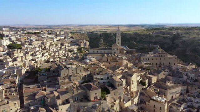 Aerial footage of Sassi di Matera in Basilicata, South Italy.Drone 360 orbit from Civita to Sasso Barisano district, old city houses carved in rock caves, stairs, bell tower of Cathedral from above