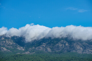 Corsica, mountains engulfed in clouds with blue sky