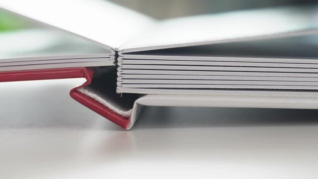 the open photobook binding with plastic pages on a white table. 