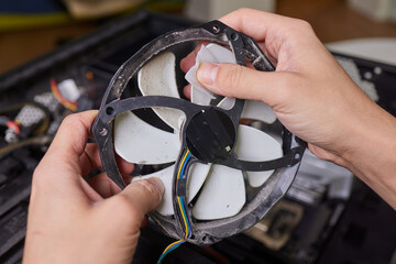 Internal parts of an old personal computer. Dusty motherboard, video card and fan. The master...