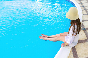 Back view young adult female woman person enjoy relaxing on swimming pool edge in luxury hotel resort outdoor looking on blue clear water. Summer travel tropical recreational vacation tourism concept