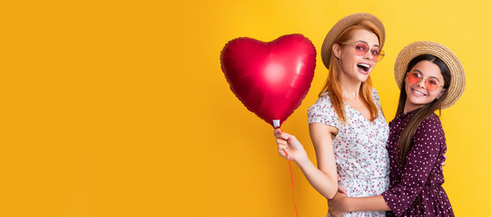 Obraz na płótnie Canvas Mother and daughter kid banner, copy space, isolated background. mom and daughter smile hold love heart balloon on yellow background.