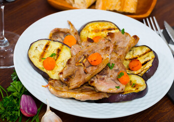 Tasty mutton loin chops grilled with eggplant slices and carrots garnished with fresh parsley