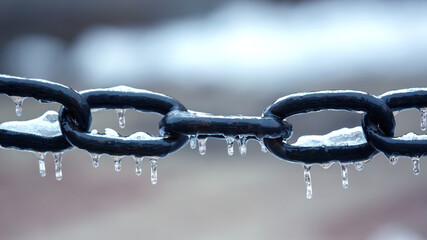 icicles on a frozen metal chain. winter weather season. street interior details