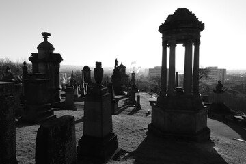 GLASGOW SCOTLAND, January, 2023: Cityscape, Glasgow Necropolis during sunset with illuminated graves and crosses