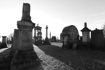 Scotland, Glasgow, United Kingdom - January, 2023: The Necropolis, a cemetery in Glasgow during sunset with illuminated graves and crosses. Cemetery With Tombs And Monuments. 