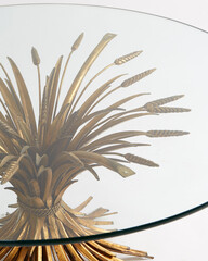 Wheat-motif sheaf glass-top coffee table. Vintage gold unique design. Close-up detail from above.
