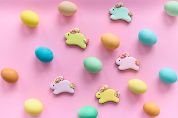 colored easter eggs  with a chocolate bunny cookies on a pink background