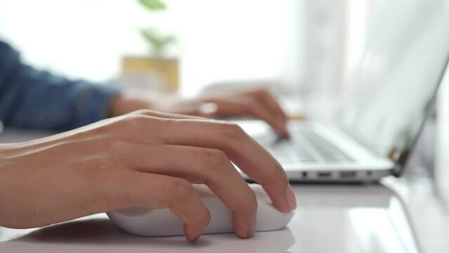 Close up of businesswoman hand using mouse working on laptop technology and business concept.