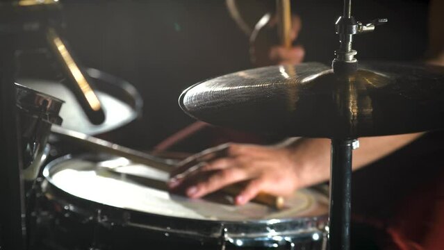 Close-up hands of drummer musician man is playing hitting drum kit and cymbals.
