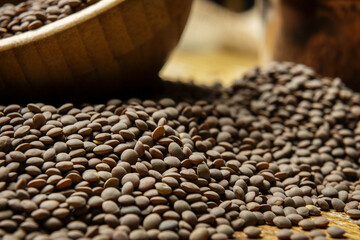 dried lentils scattered on a wooden table with bamboo wooden bowls