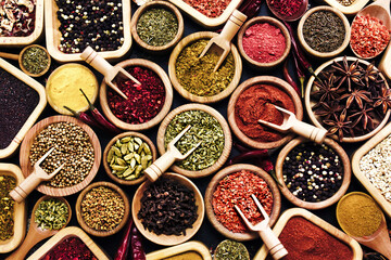 Colorful mix of herb and spice varieties: curry and coriander, turmeric and cumin, paprika and pepper, mustard and salt, cardamon and oregano and saffron. Food ingredients background